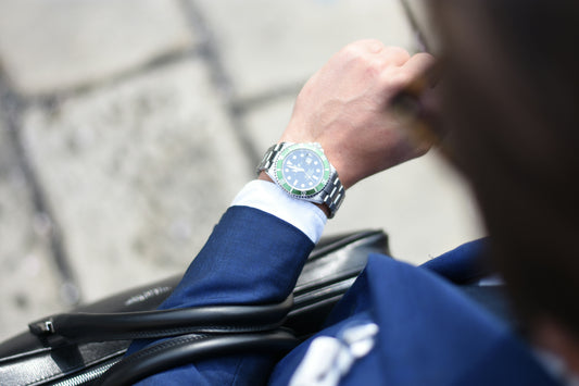 Business professional in blue suit checking luxury wristwatch.